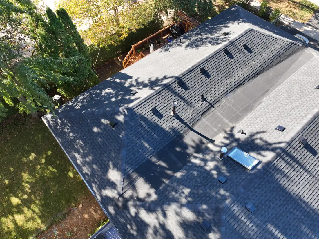 Angled drone view of the finished Bonnymede Drive roof corner with new hip caps and box vents